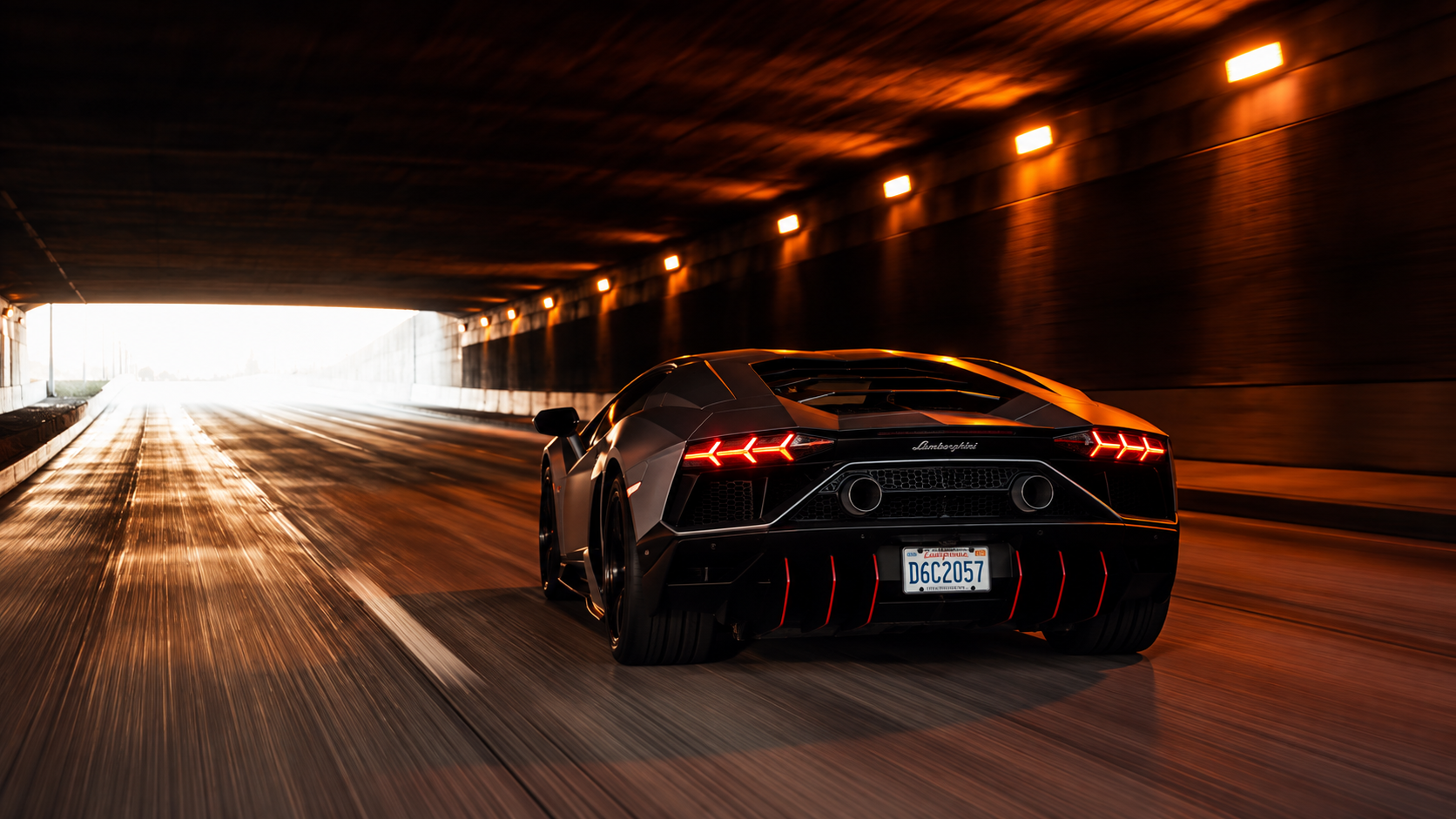 Lamborghini oscuro circulando de espaldas por un t&uacute;nel hacia la salida iluminada